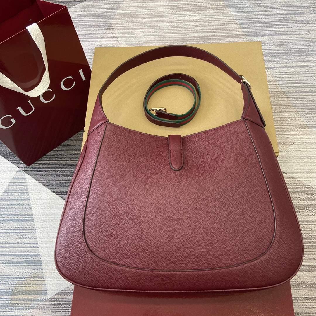 Grand sac bandoulière Jackie 40 en cuir de veau bordeaux et rouge, matériel doré