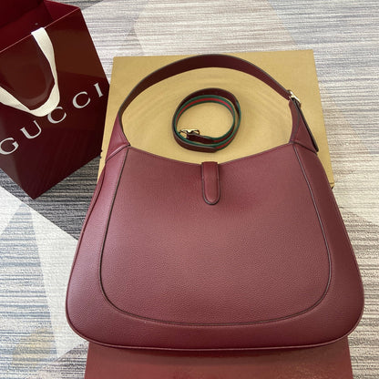 Grand sac bandoulière Jackie 40 en cuir de veau bordeaux et rouge, matériel doré