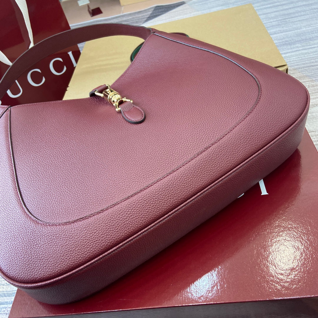 Grand sac bandoulière Jackie 40 en cuir de veau bordeaux et rouge, matériel doré
