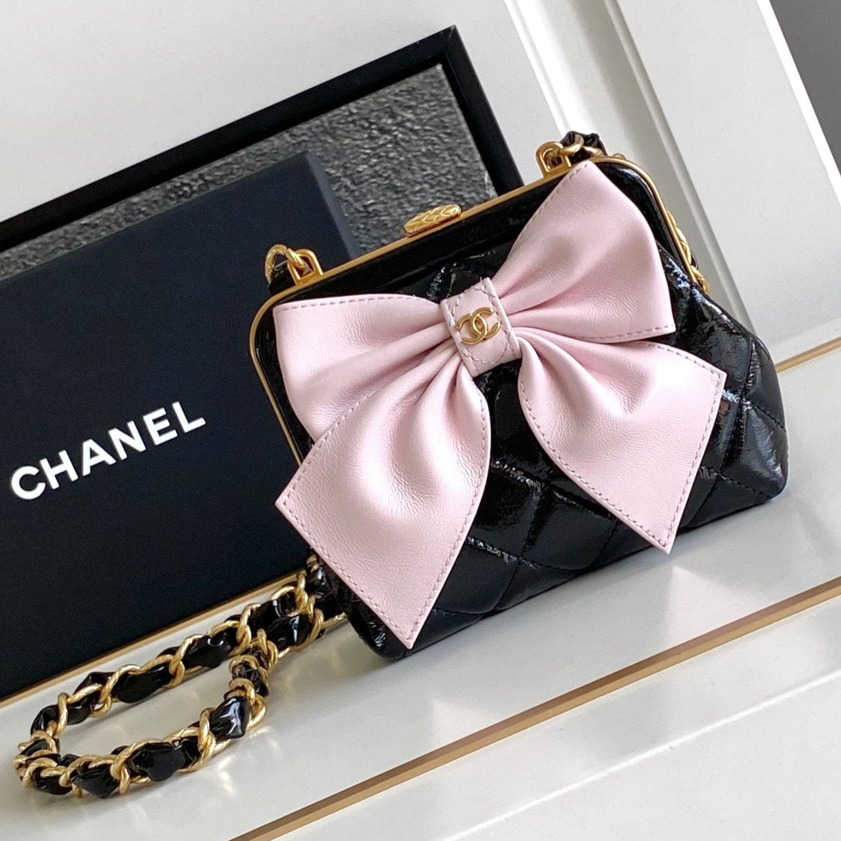Pochette CC MINI 13 avec bandoulière en cuir d'agneau noir et nœud rose