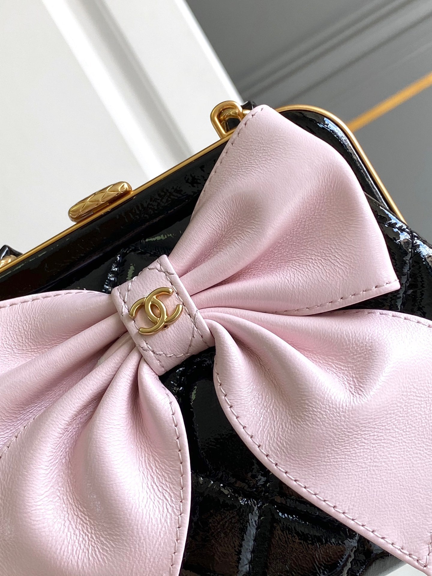 Pochette CC MINI 13 avec bandoulière en cuir d'agneau noir et nœud rose